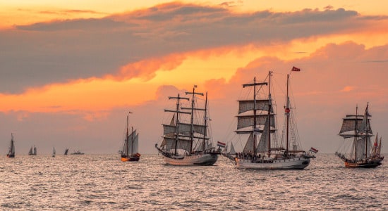 Flotilla of sail ships transporting goods across the world